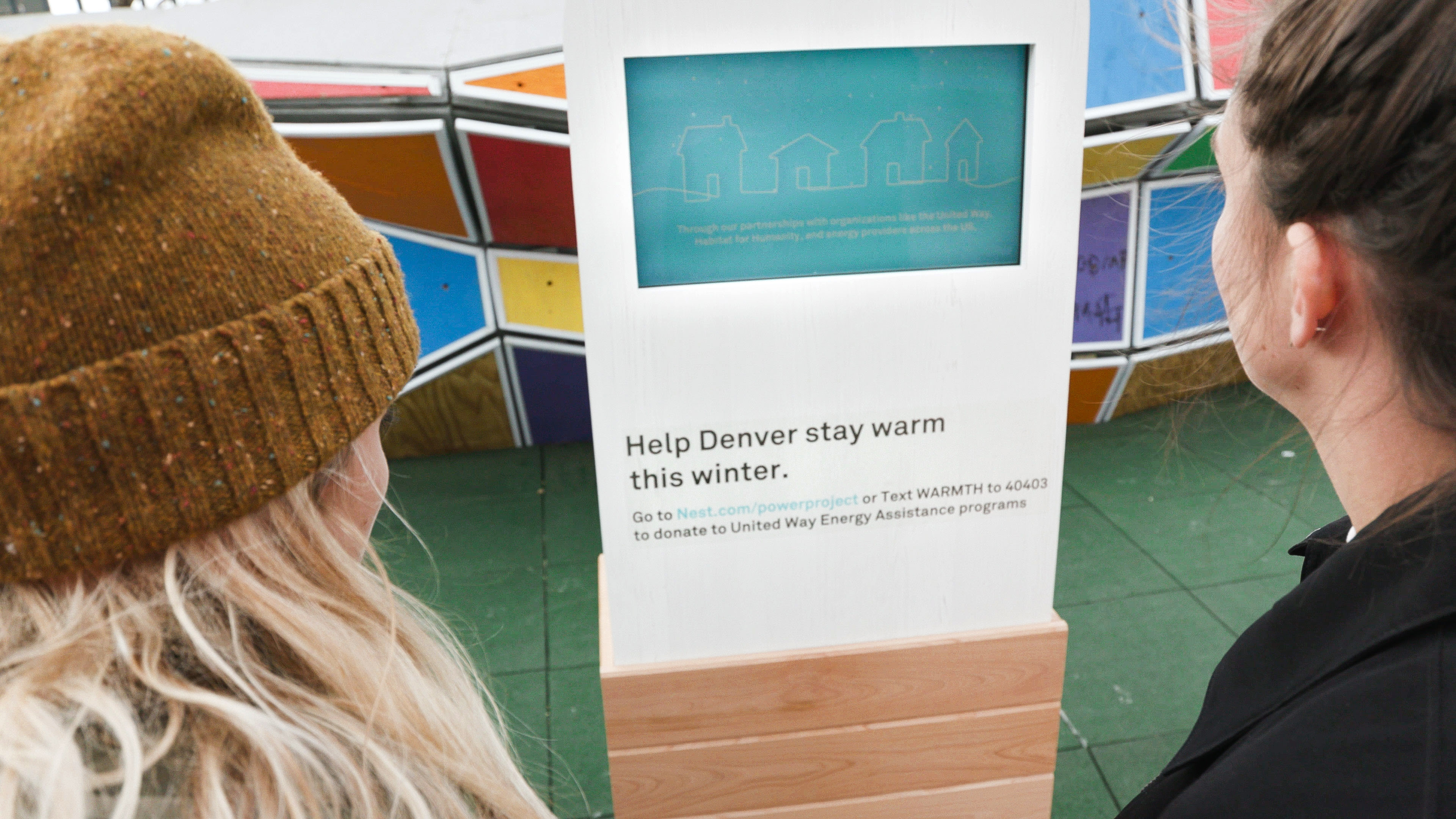 Two people looking at a donation platform that is part of the Power Project and a partnership between Nest and United Way to make donating to energy assistance funds easy for neighbourhoods across the country.