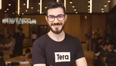 Grupo de pessoas posando para foto junto a uma placa com o logo da Tera.