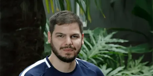 Homem sentado posando para foto.