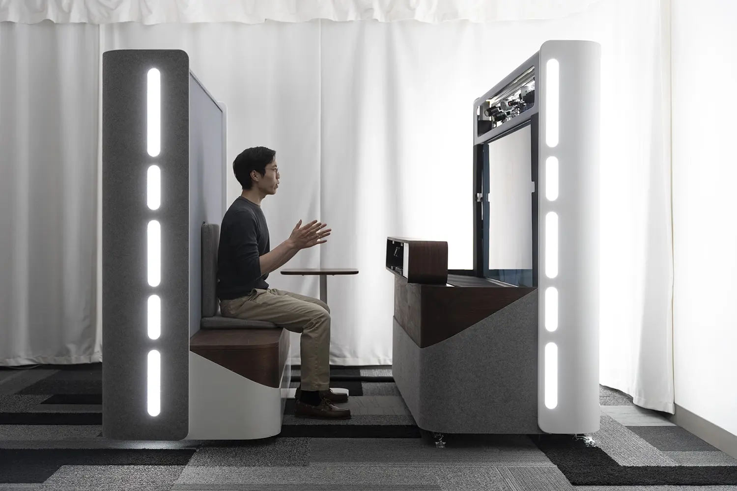 A side-profile view of a person seated in front of a Project Starline prototype device.