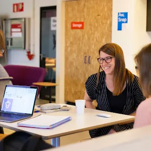 Couple of women and a man sits around a table and discussing.