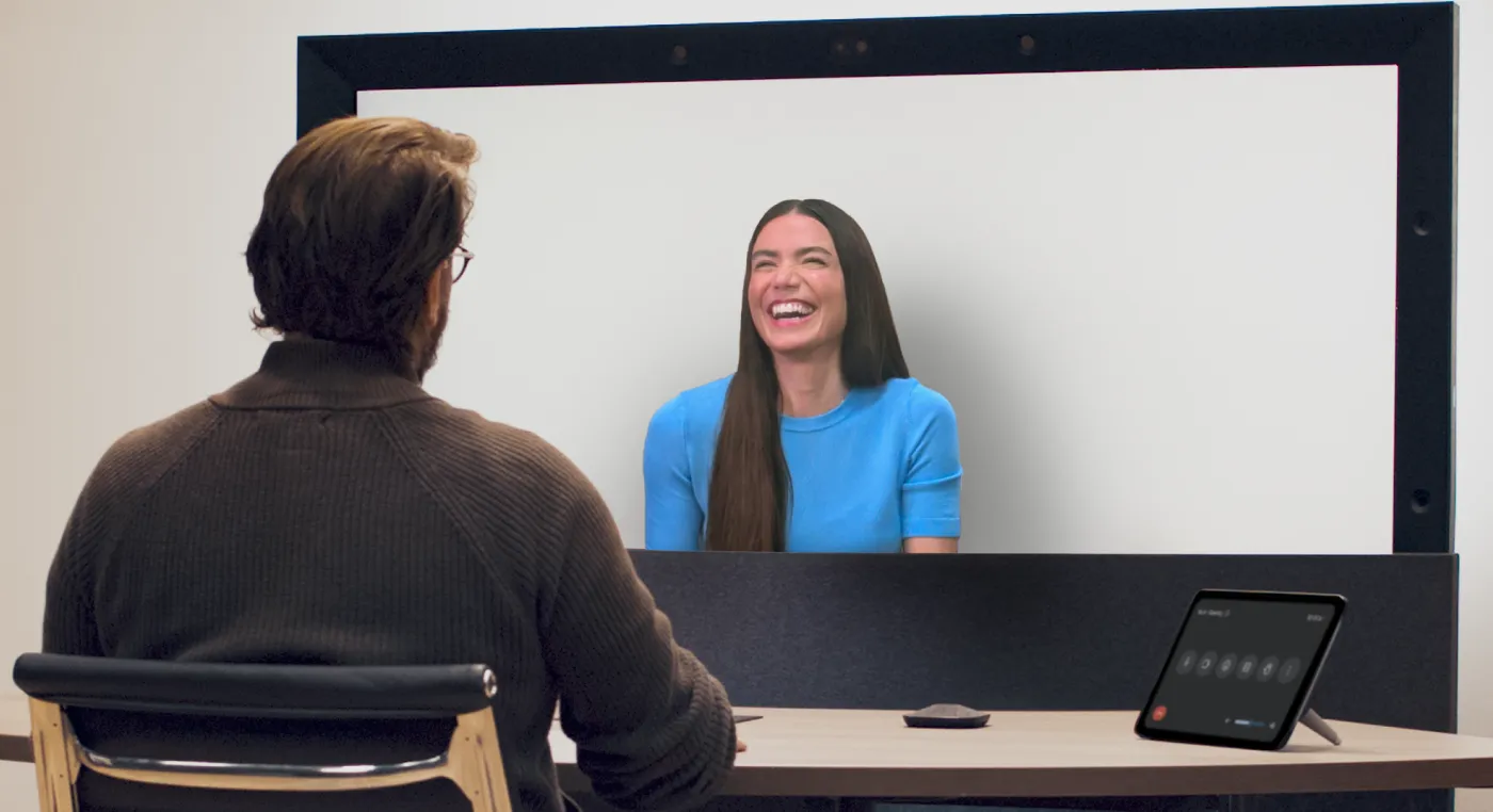 A carousel of images and videos shows the evolution of Google Beam devices over time.
Two people converse during a Google Beam video meeting.