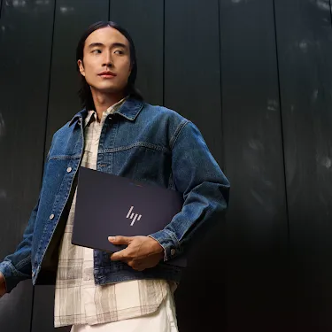  Person carrying a Googlebook outdoors.