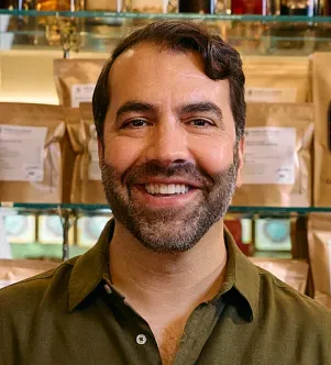 A photograph of Anthony Qaiyum, the owner of Merz Apothecary, a Chicago-based herbal pharmacy and wellness shop.
