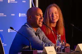 Googler David Graff speaking at the TPI Aspen Forum with moderator Sarah Oh Lam smiling beside him.