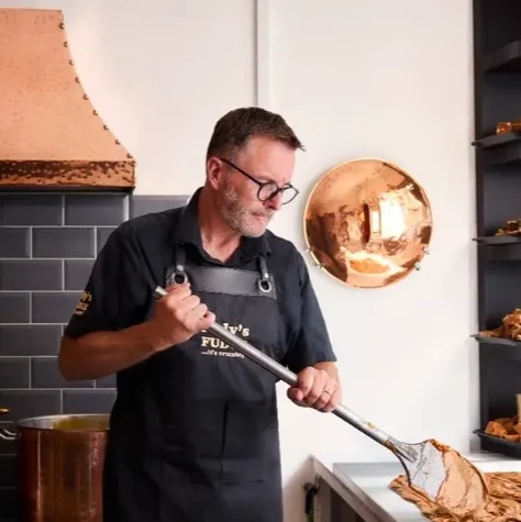 An image of Matthew Pugh, owner of Rolys Fudge Dartmouth, working on his family-run business
