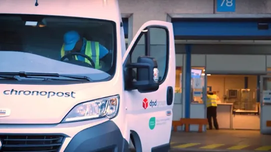 A white Chronopost delivery van with the DPD Group logo, parked at a loading dock with a driver inside.