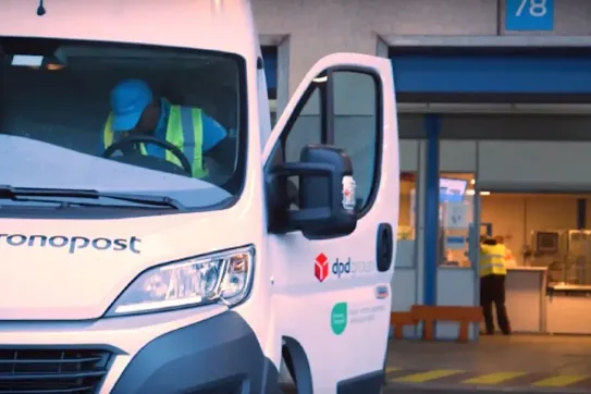 A white Chronopost delivery van with the DPD Group logo, parked at a loading dock with a driver inside.