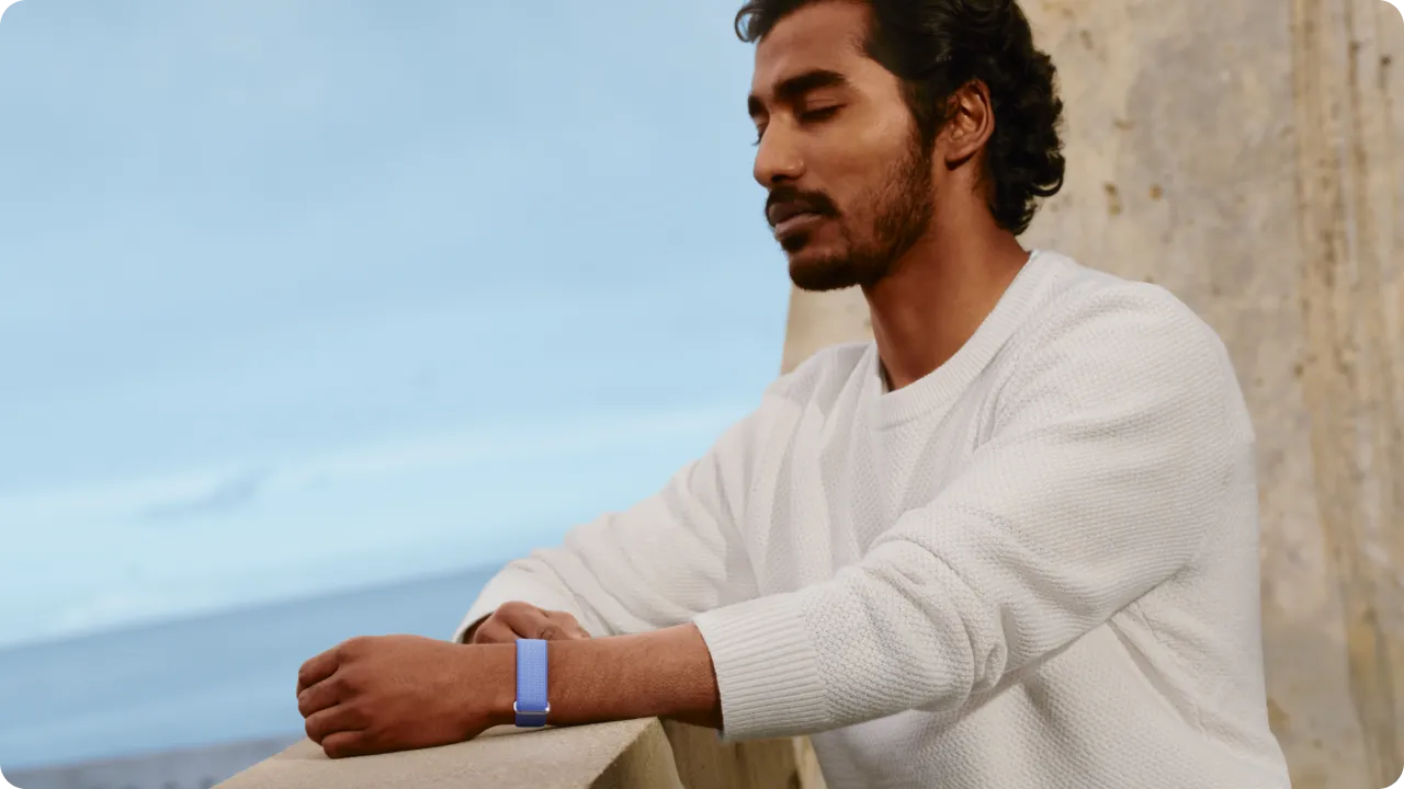 A man wearing a Google Fitbit Air closes his eyes for a moment of respite