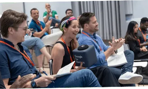 Grupo de personas sentadas en sillas aplaudiendo durante la terapia.