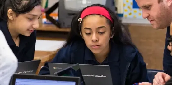 Image of children at laptops in a classroom