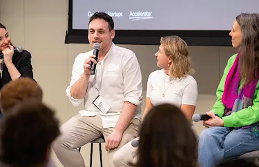 A group of people is engaged in a deep discussion, with microphones in their hands.