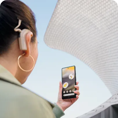 Person with a cochlear implant holds Android phone in front of them.