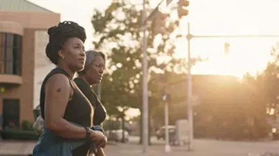 The founders, Ashlee Ammons and Kerry Schrader, walk along a street at sunset.