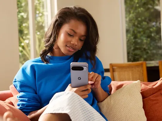 Woman using an Android phone indoors and lightly smiling at the screen.