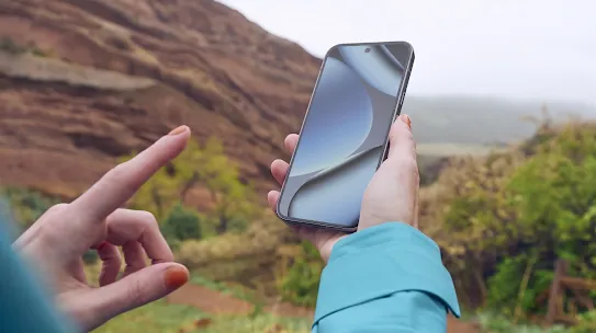 Eine Frau, die ein Android-Smartphone in der Natur benutzt. 