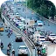 High-angle view of a congested multi-lane city highway filled with a dense mix of white and silver cars, numerous motorcycles, and colorful tuk-tuks during a busy commute.