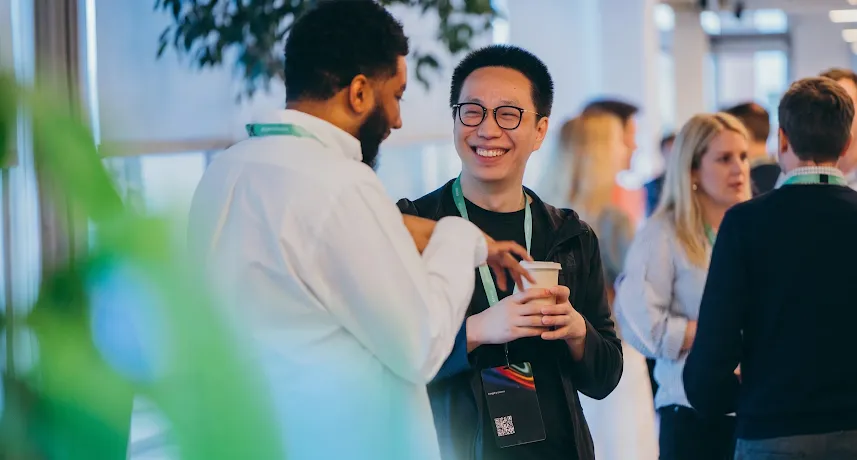 Two professionals conversing and smiling at an event, with the Google for Startups logo overlay.