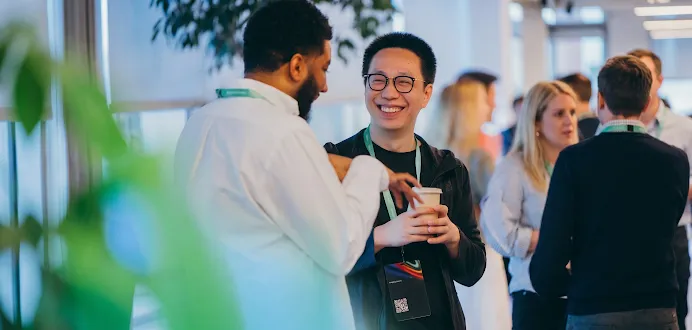 Two professionals conversing and smiling at an event, with the Google for Startups logo overlay.