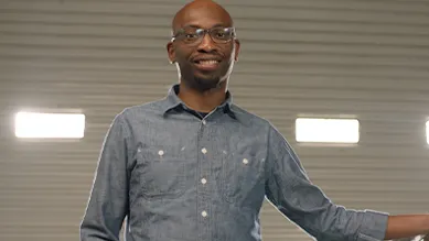 Founder Seyi Fabode smiles at the camera inside his garage-turned-office.
