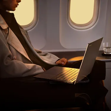 Person using a Googlebook on an airplane.