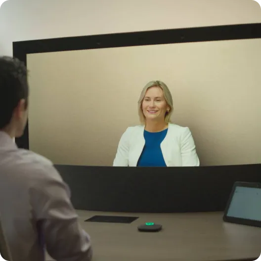 A person talking to a true-to-life representation of a colleague during a Google Beam video meeting.