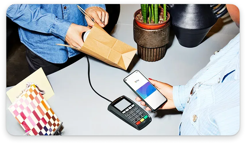 Person holding a phone to a contactless payment system