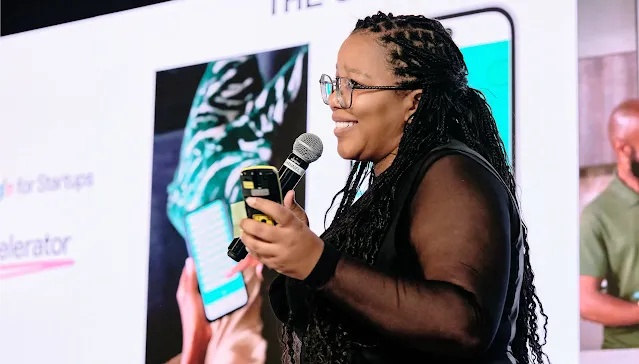 With a mic in one hand and her phone in the other, the woman leads the event and engages the crowd.