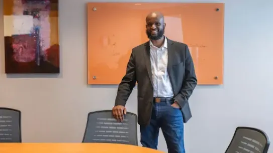 One of the male co-founders of Ilmiya posing at a desk