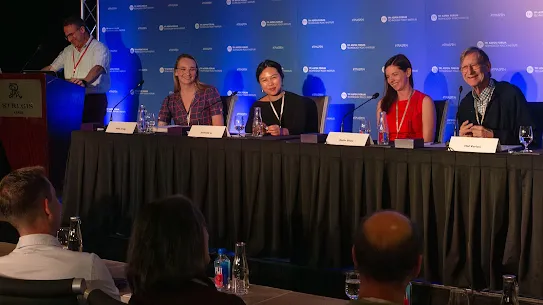 A panel discussion at the TPI Aspen Forum featuring (from right) Hal Varian, Katie Shay, Danielle Li, and Halie Craig, with moderator Scott Wallsten at the podium. The panelists are seated at a long table against a blue TPI branded backdrop.