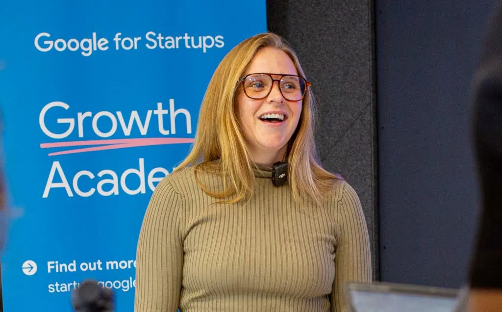 A woman wearing spects is smiling.