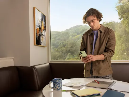 A man using his Android smartphone indoors.