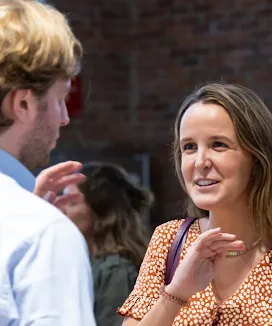 Woman chatting with a man, smiling.