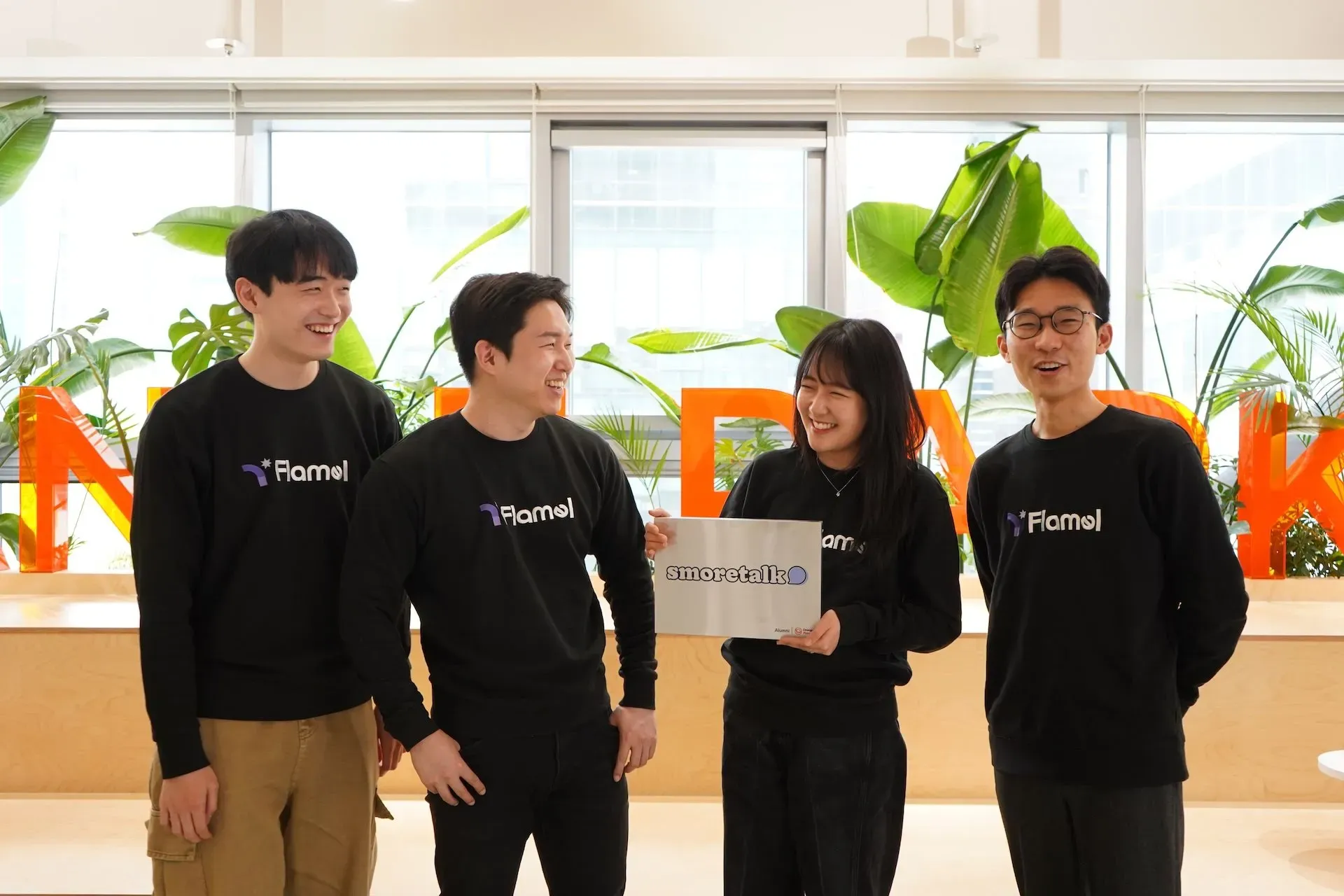 Female co-founder Hyeonji Hwang and male co-founder Jeongmin Lee, surrounded by the Smoretalk team