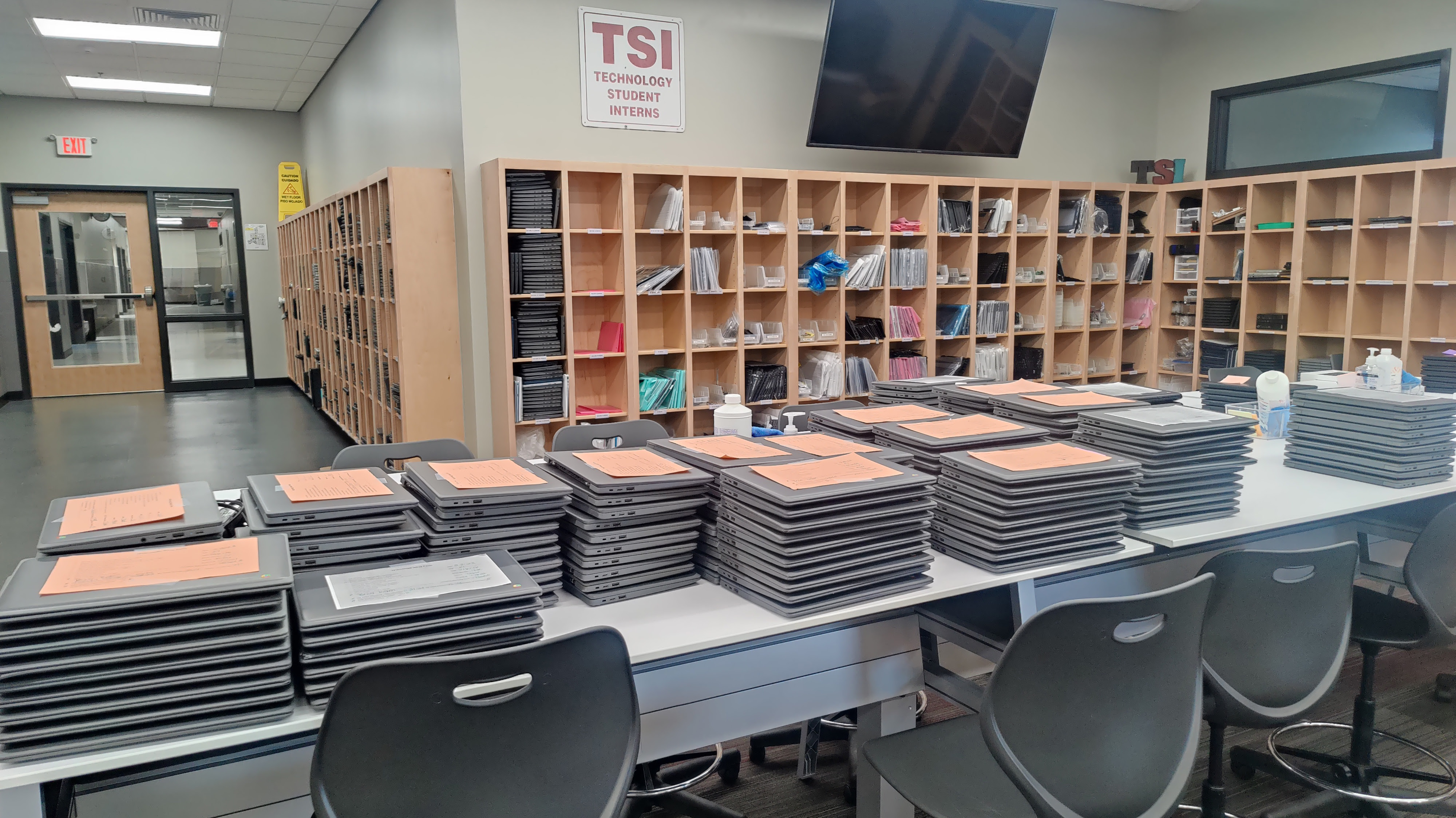 Stacks of Chromebooks on a table awaiting repair