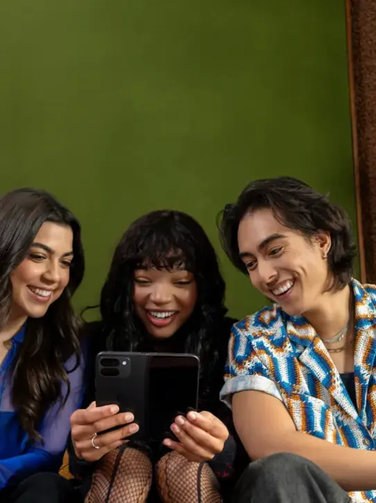 Des personnes assises ensemble, tenant des appareils Android
