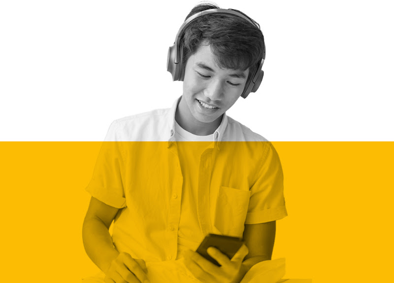 A Singaporean man using his phone with headphones on