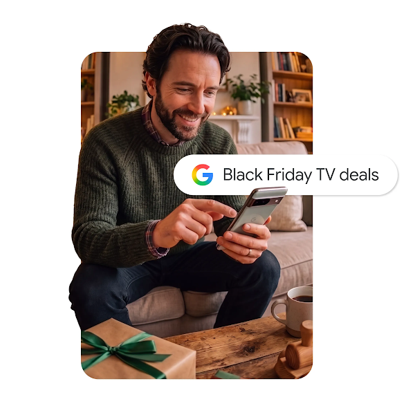 A graphic of a smiling man sitting on a couch, using a smartphone with a Google search bar overlay that reads "Black Friday TV deals."