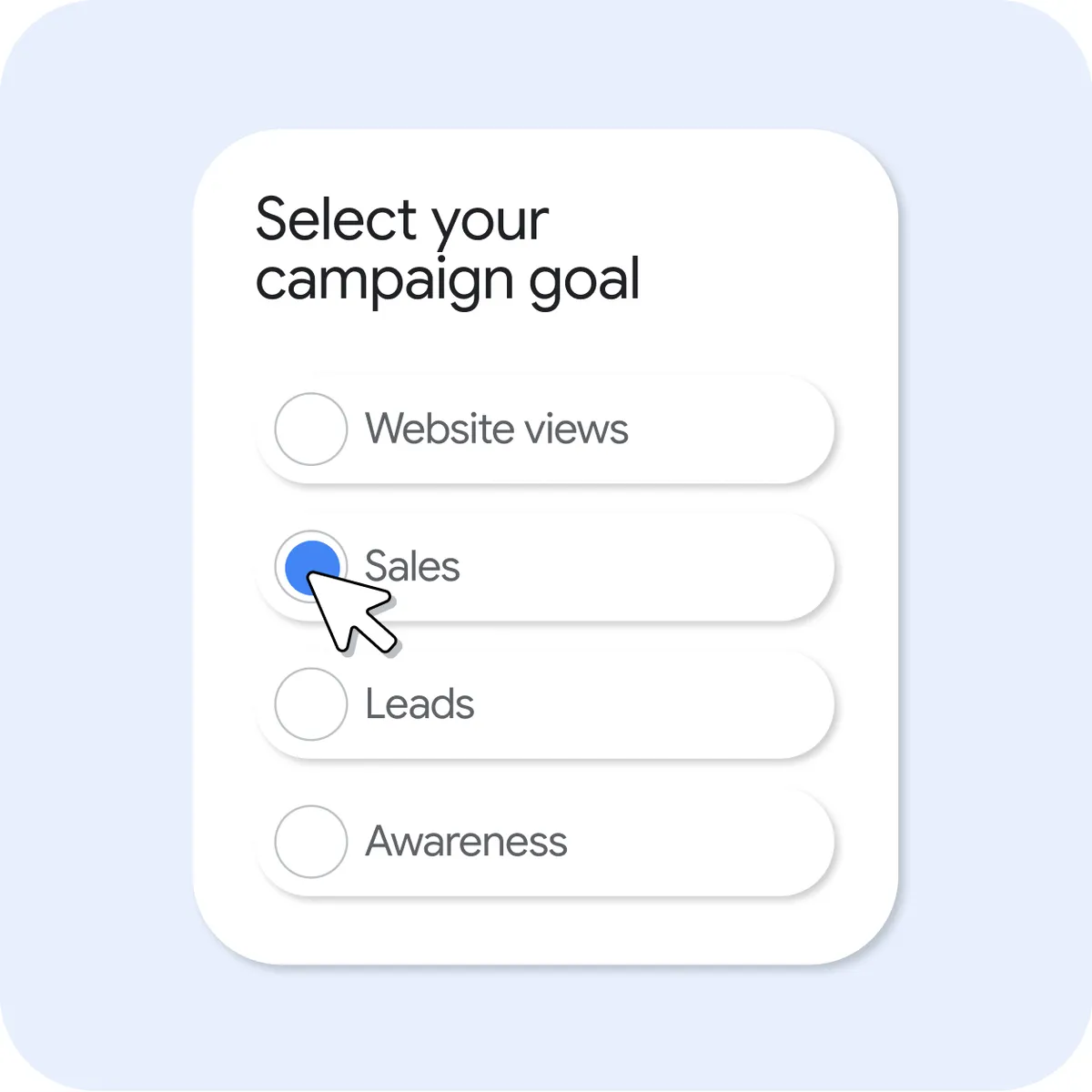 Card-style UI titled “Select your campaign goal” showing four radio options: Website views, Sales, Leads, and Awareness. The “Sales” option is selected with a blue radio button, and a cursor is clicking on it.