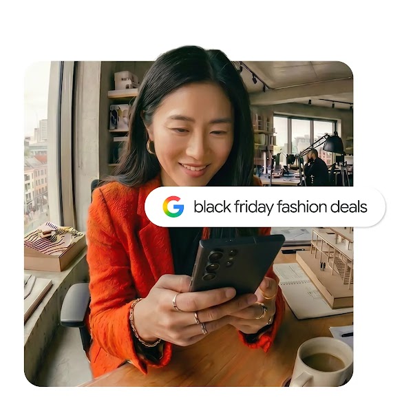 A woman in an orange jacket looking at her smartphone in a bright office, overlaid with a Google search bar reading "black friday fashion deals".