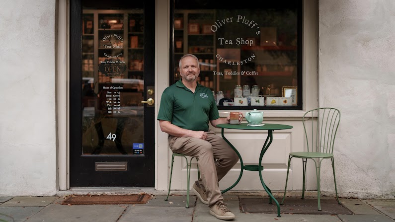 Oliver Pluff & Co. owner sits outside his tea shop.