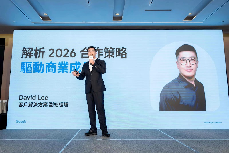 業界男性講者於會議廳前展示 Google AI 行銷工具生態。大螢幕呈現「Google AI + Marketer」主題，分為兩大解決方案：左側「創意內容」區塊展示 GenMedia on Vartex AI 與「AI 生成式創意素材」（GenMedia）；右側「廣告媒體與個人化」區塊展示 Google AI Max 與「AI 賦能廣告活動」（AI Max for Search）。背景裝飾為現代藍色調搭配 Google 品牌元素。現場多位與會者認真聽講。此展示強調 Google AI 從內容創意到廣告轉換的完整行銷轉型解決方案，協助代理商提高效能與創造最大價值。