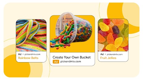 Against a yellow background of different shades, three ads for pickandnmix.shop. From left to right, ad copy reads: “Rainbow Belts”; “Create Your Own Bucket”; and “Fruit Jellies”. Each ad has an image of assorted sweets above the copy.