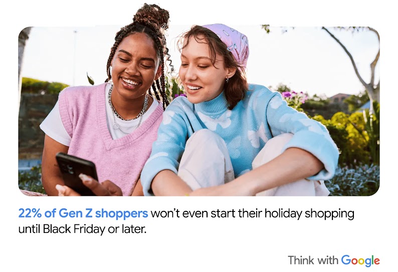 Two young people sit outside and smile while looking at a mobile device. “22% of Gen Z shoppers won’t even start their holiday shopping until Black Friday or later.”