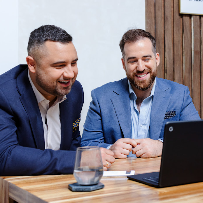  Duas pessoas olham para um laptop e sorriem. Um botão que diz “15x retorno sobre o investimento em anúncios” aparece abaixo delas.