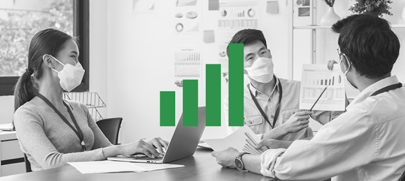 Three people looking at charts during a work meeting in a Hong Kong office