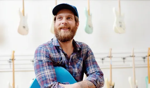 Photo of man with a guitar.