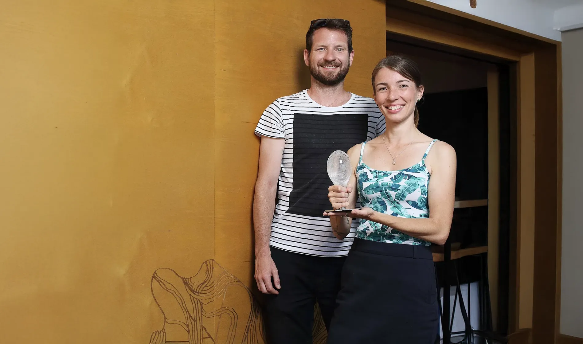 Zuzana Měřínská a Pavel Bechyně, majitelé kavárny Smetanka, stojí před stěnou s nápisem Kafe Smetanka a drží ocenění Křišťálový špendlík.