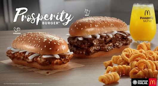 The video thumbnail depicts an extreme close-up of the iconic oblong-shaped Prosperity Burger, showcasing its juicy beef or chicken patty, generous black pepper sauce, and fresh onions between a sesame seed bun, often accompanied by the Curly Fries.