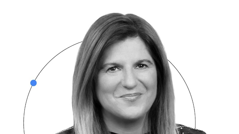 Google'ın CMO'su Lorraine Twohill'in gülümseyen bir portre fotoğrafı gösteriliyor. Açık renk saçlı ve açık renk tenli Twohill siyah bir üst giyiyor. Twohill'in yüzünün üst kısmı şeffaf bir mavi daireyle çevreleniyor. Arkasında ise sarı noktalı, kavisli bi